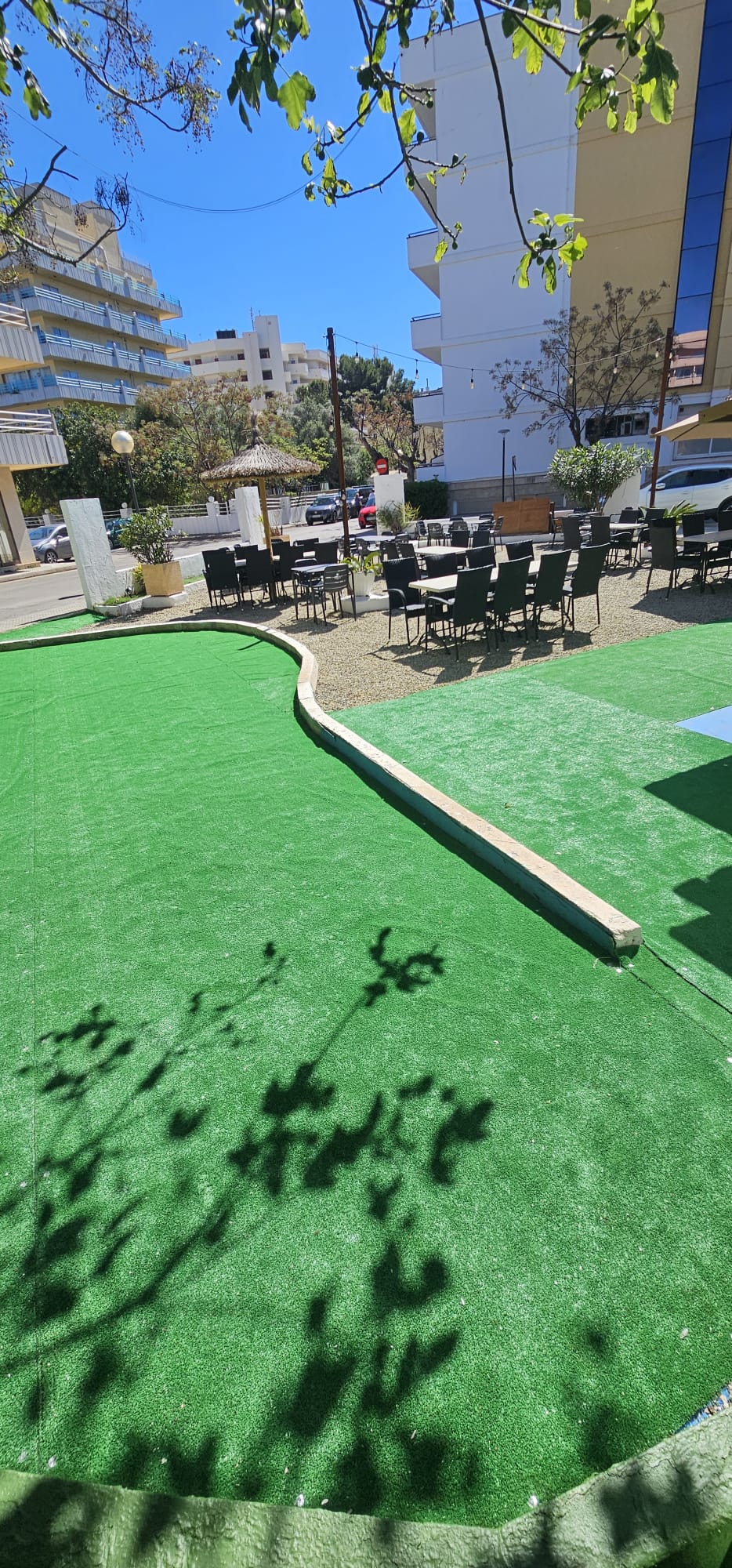 Área externa com mesas e gramado verde
